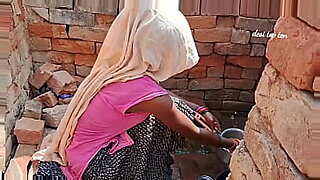 Housewife gets surprise from husband while washing dishes in kitchen.