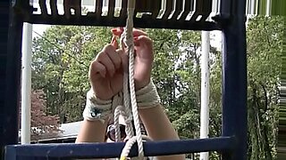 Nyssa Nevers tied up in outdoor bondage, her long hair swinging wildly.