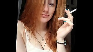 Redhead Alice has a smoke.